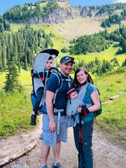 A family with two young children hiking in a mountainous landscape