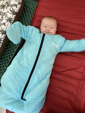 A baby wearing a Morrison Outdoors Little Mo 20 sleeping bag