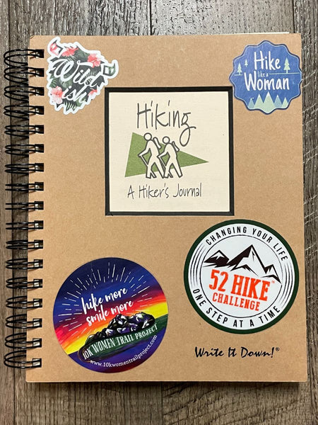 A Hiking Journal decorated with stickers from the 52 Hike Challenge, Hike Like a Woman, and others