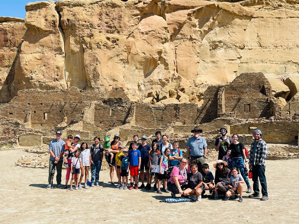 A group of kids and families in front of a rock formation in New Mexico