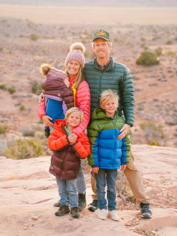 A family of 5 in a scenic outdoor landscape with a toddler being carried in a Trail Magik kid carrier attached to a hiking backpack